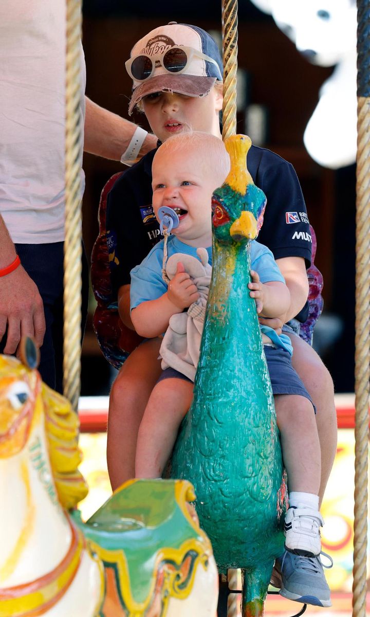 Lucas smiled while riding a carousel with his sister Mia.