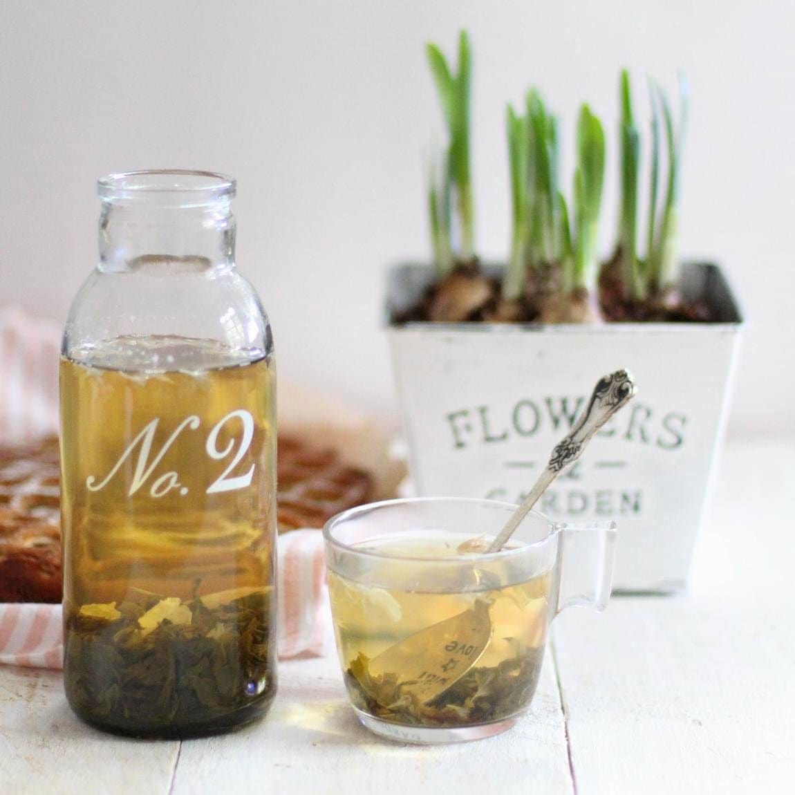 Green tea in a glass bottle and in a glass
