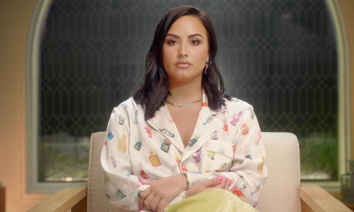 Demi Lovato sitting in a chair.