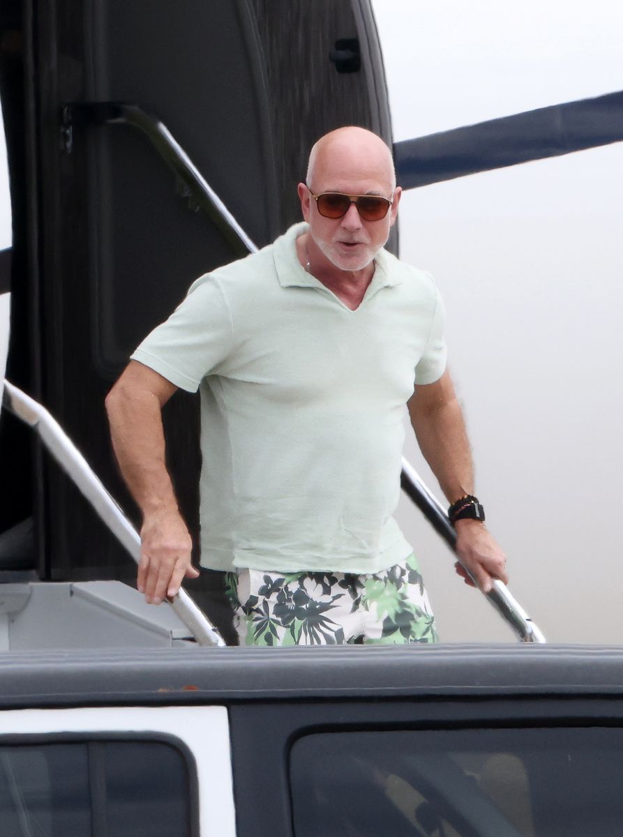 Lauren Sánchez Bezos wore a colorful mini dress with a psychedelic print paired with oversized sunglasses, while Jeff Bezos wore a pale green polo shirt with tropical-print shorts and sunglasses.