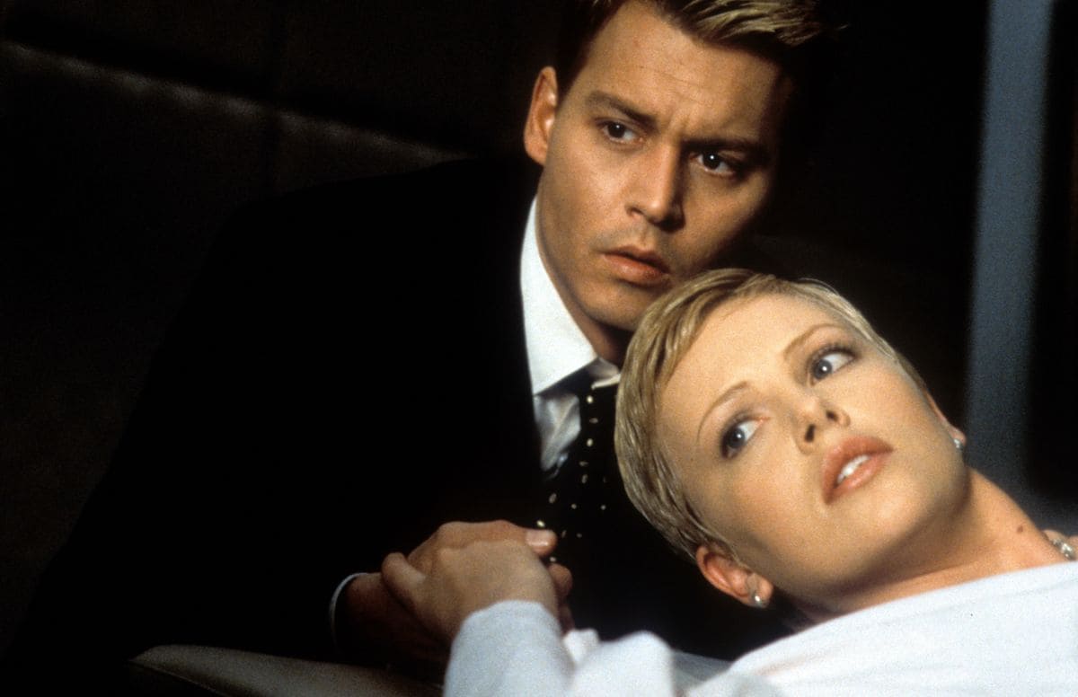 Johnny Depp holding Charlize Theron's hands in a scene from the film 'The Astronaut's Wife', 1999. 