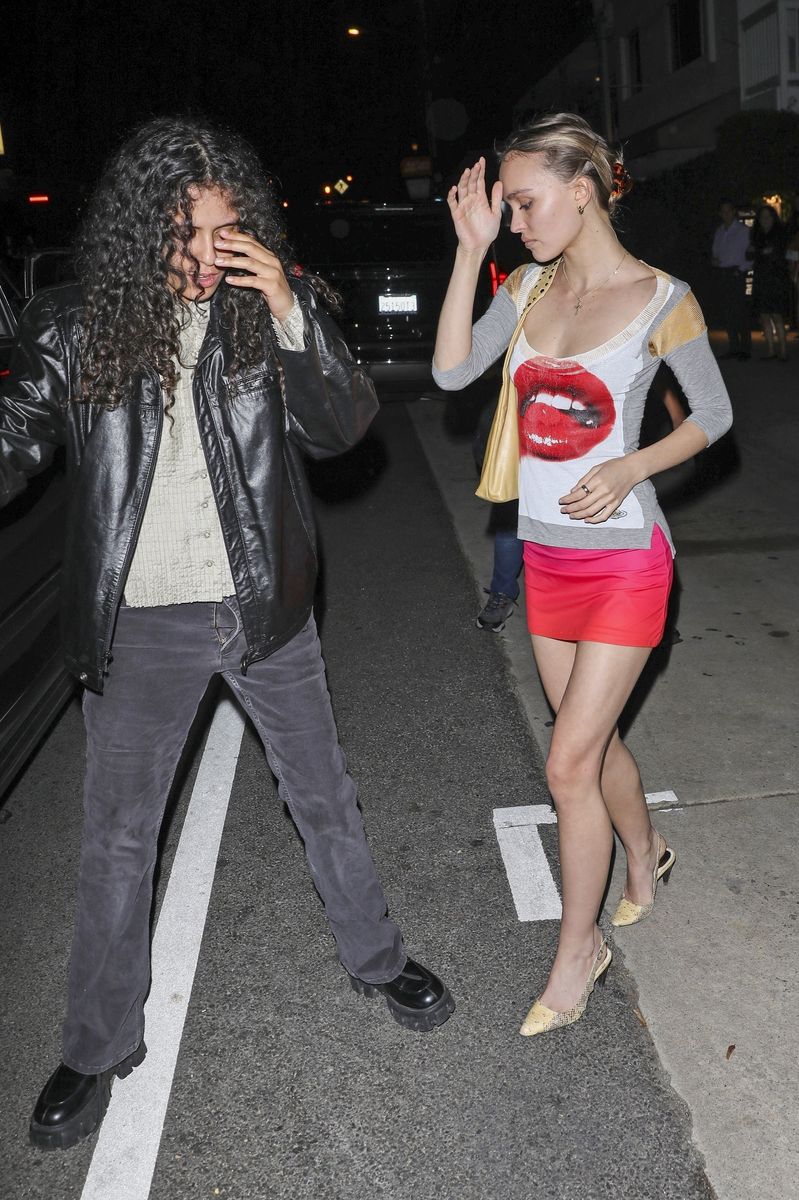 Lily-Rose Depp wears a red mini skirt as she and girlfriend 070 Shake hold hands while exiting Italian restaurant Giorgio Baldi after having a romantic dinner date in Santa Monica. 
