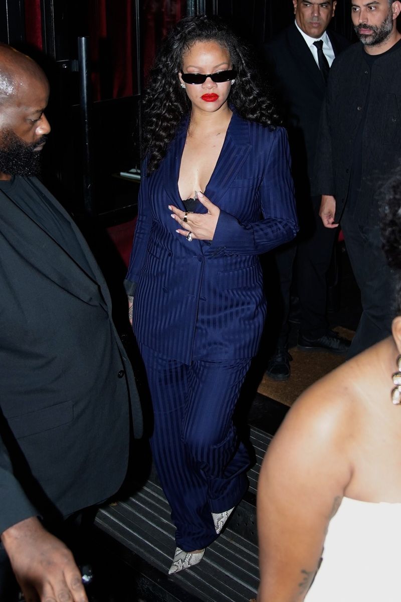 She styled the tailored ensemble with snake-print pointed-toe stilettos, narrow black sunglasses, a sparkling silver handbag and a visible black lace bralette.