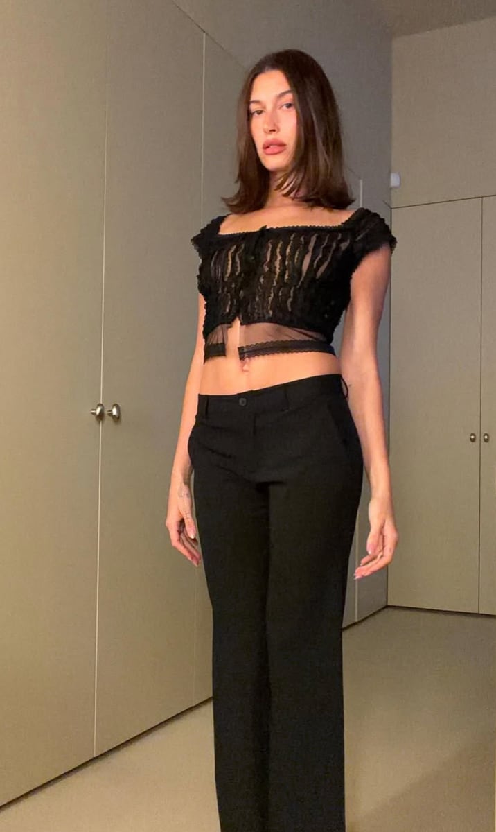 Hailey Bieber wore a sheer black lace blouse with short sleeves and a cropped cut