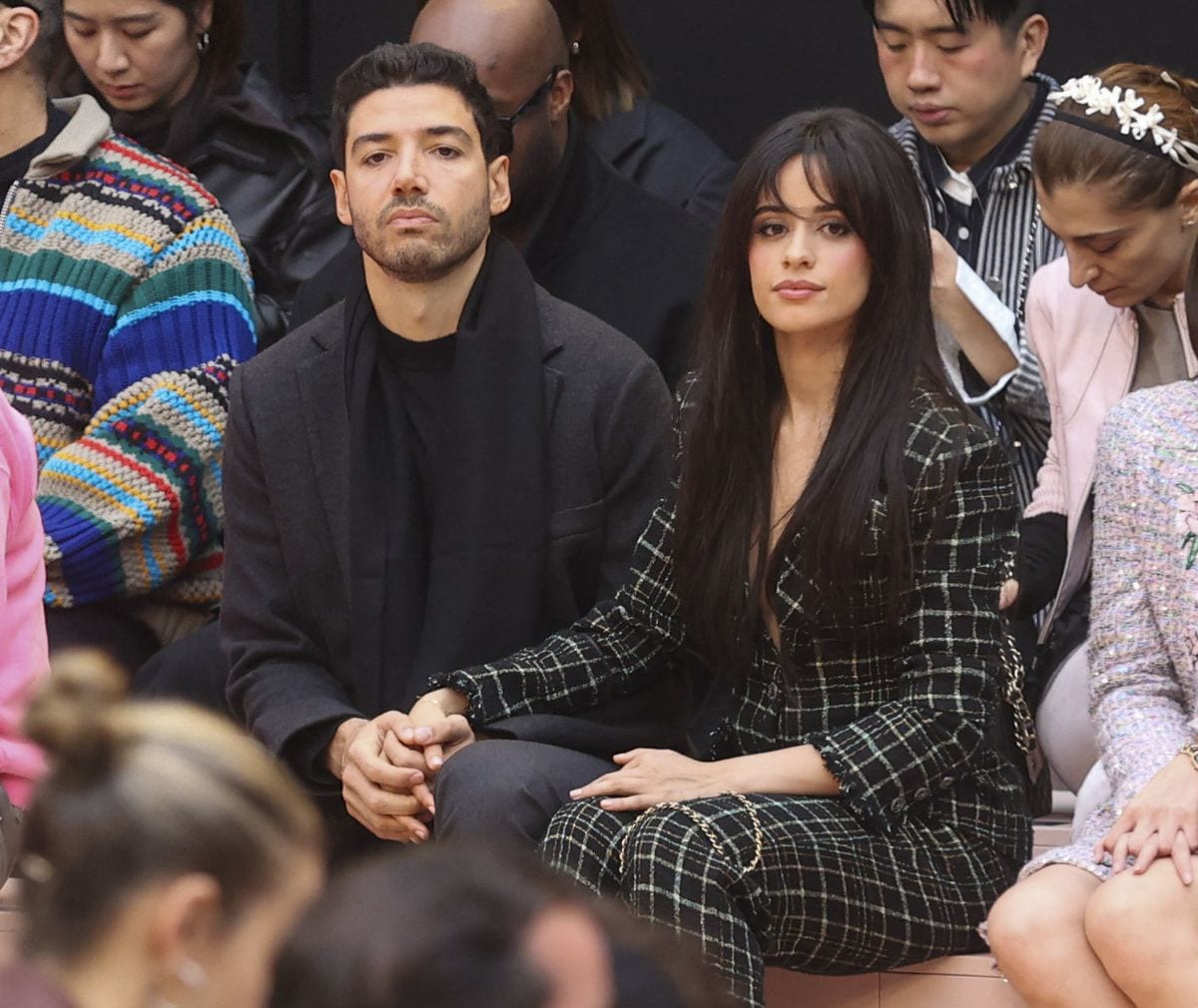 Camila Cabello attends the Chanel Fall/Winter 2025-2026 show wearing a chic plaid suit, accompanied by her boyfriend Henry Junior Chalhoub