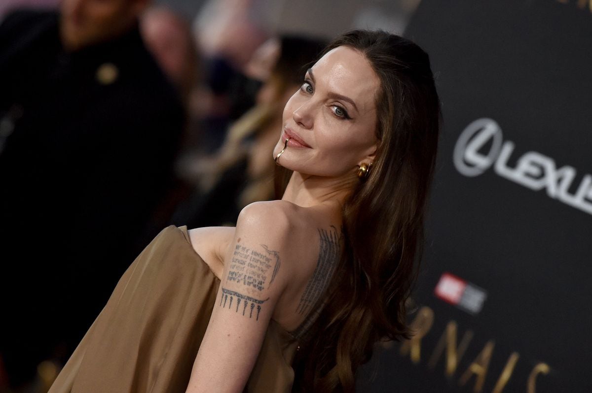 Angelina Jolie attends the Los Angeles Premiere of Marvel Studios' "Eternals" in strapless dress and gold lip cuff