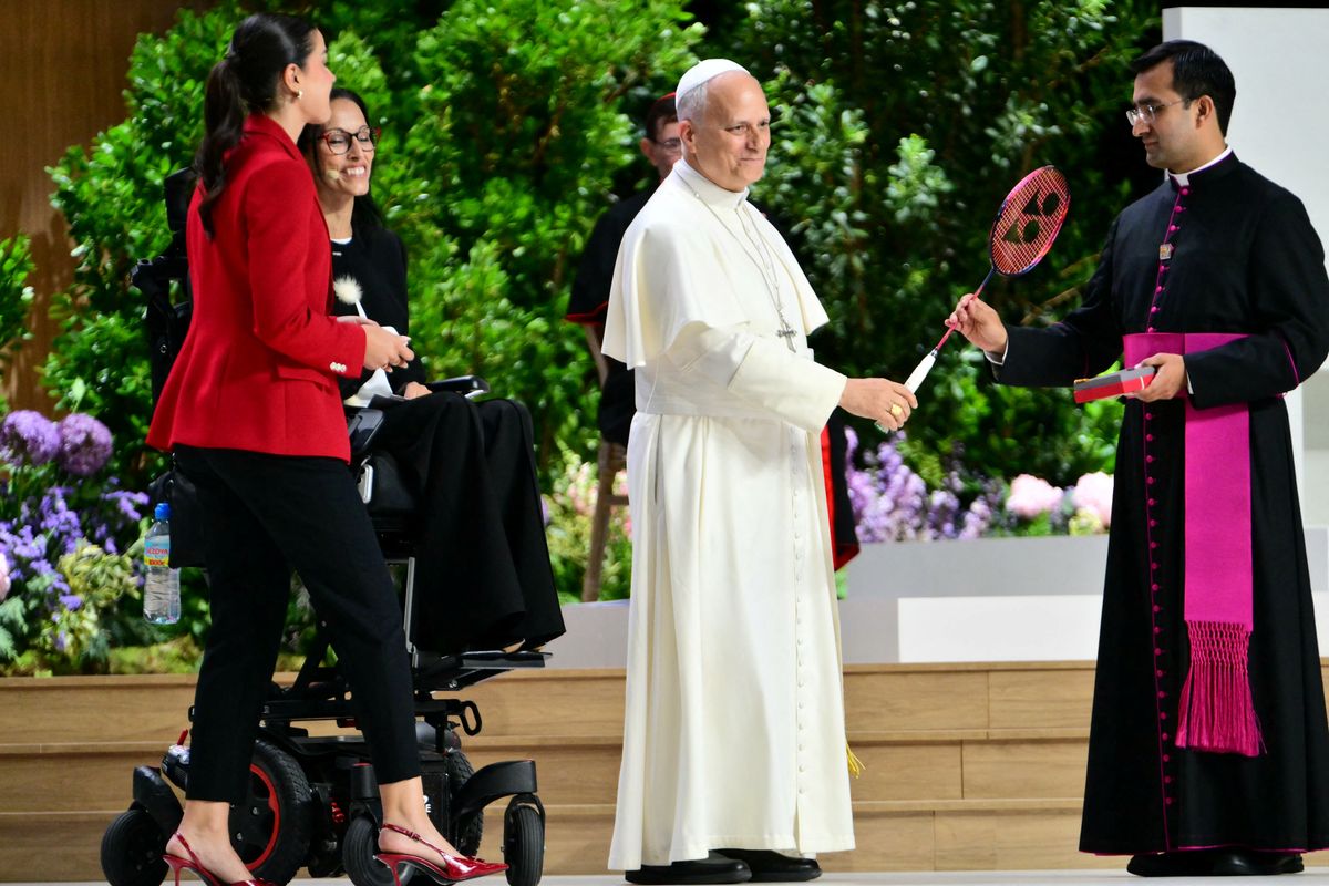 Pope Leo XIV receives gifts from Spanish Olympics badminton champion Carolina Marin (L) and Spanish paralympic swimmer Teresa Perales (2L) during the meeting "Building networks with the world of Culture, Art, Economy and Sports" at the Movistar Arena in Madrid on June 7, 2026.