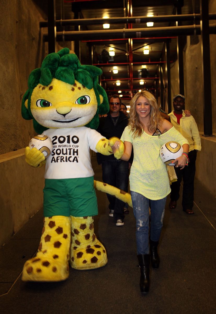 Shakira walks with official mascot Zakumi during a FIFA Media briefing ahead of the World Cup Final match between Netherlands and Spain.