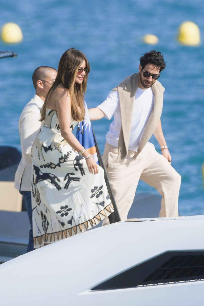
Sofia Vergara is seen leaving the Hotel Eden Roc in Antibes during the 9th day of the Cannes Film Festival 2025. The actress looked stunning in a strapless, cinched white dress adorned with bold black embroidery, radiating Mediterranean chic. She was also joined by a very affectionate mystery man.bre misterioso muy cariñoso.