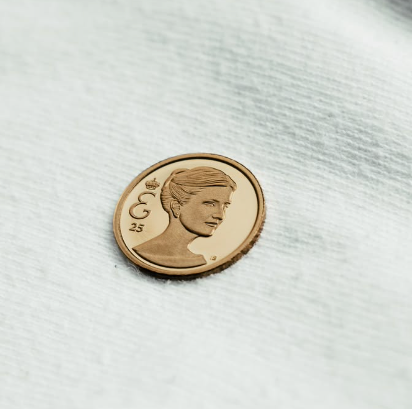A commemorative coin features Elisabeth’s portrait alongside her personal monogram and the number 25.