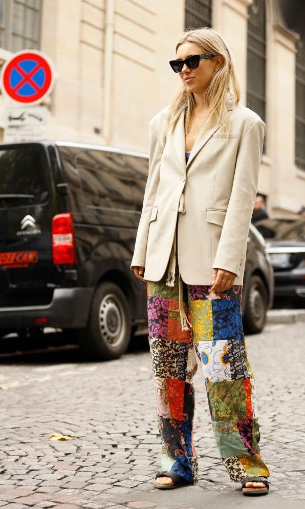 A guest wearing Ferragamo sunglasses, beige blazer, and mixed print pants