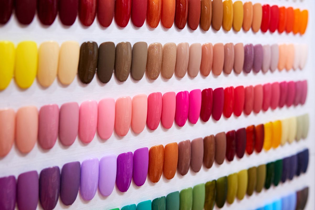 Multi-colored nails palette at white background.