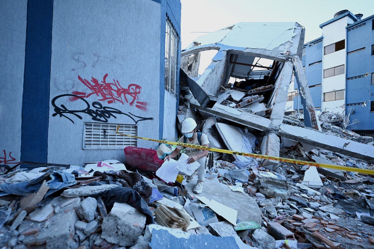 A man searches for belonging amid the rubble of a collapsed house after an earthquake in Pereira, Colombia on August 11, 2026.
