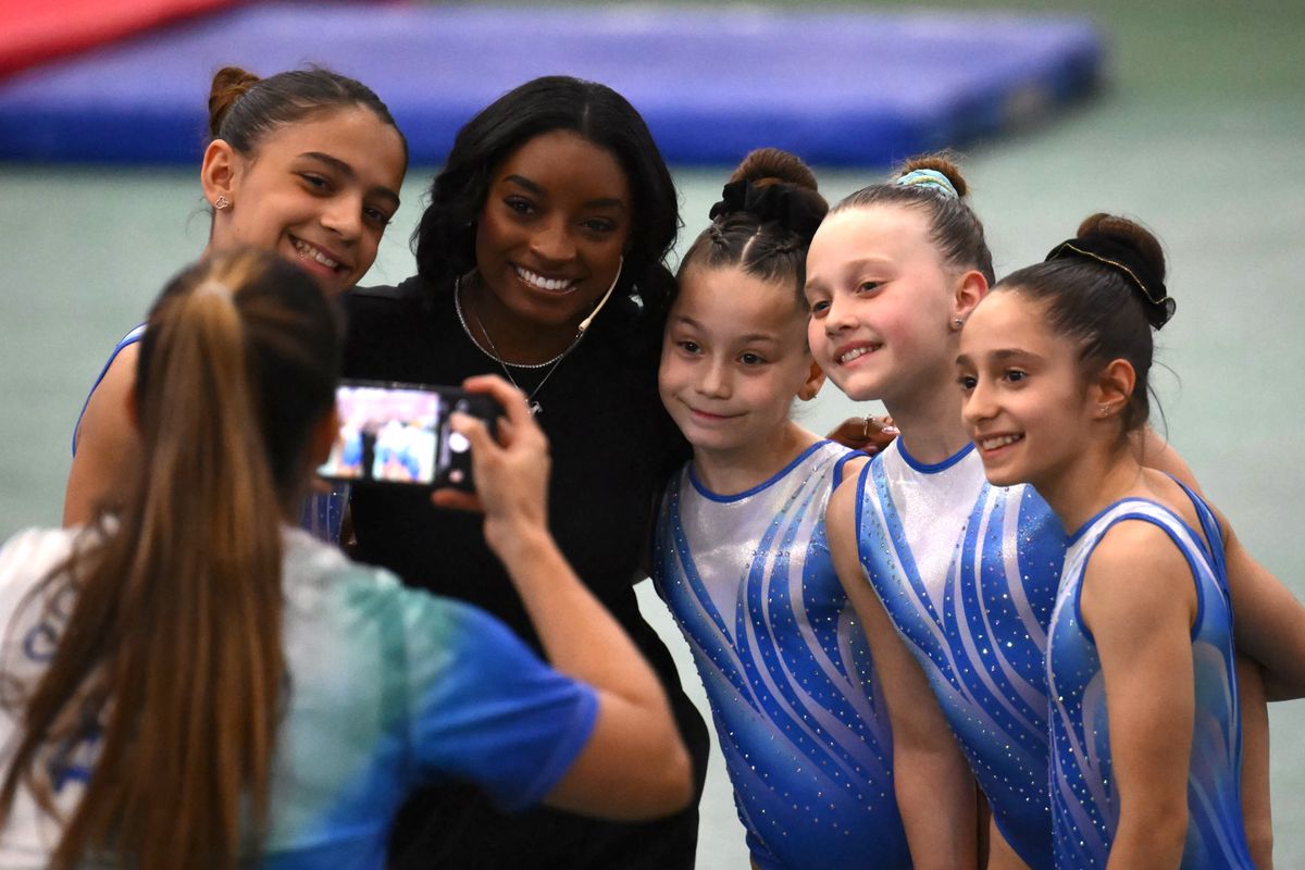 US Olympic gymnast Simone Biles poses for a picture with young gymnasts during a gymnastics clinic at the Mary Teran de Weiss Stadium in Buenos Aires