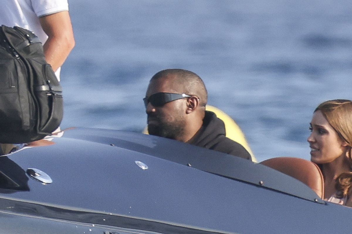 Kanye followed Bianca along the shoreline wearing a black hoodie, matching shorts and chunky cream boots.