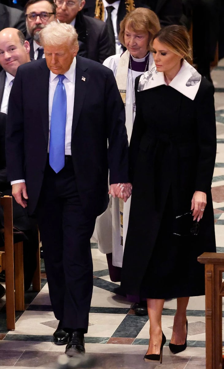 The standout feature of her outfit was a striking large white collar, adorned with a print of a 19th-century kiss sculpture. It depicted a couple embracing, surrounded by roses and butterflies.