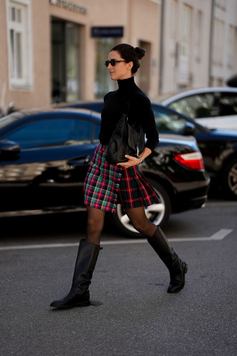 Farina Maria Pavel is seen wearing a black turtleneck sweater from Massimo Dutti; a red green and navy tartan mini skirt from La Farestia; black sheer tights; black leather knee high boots from Massimo Dutti