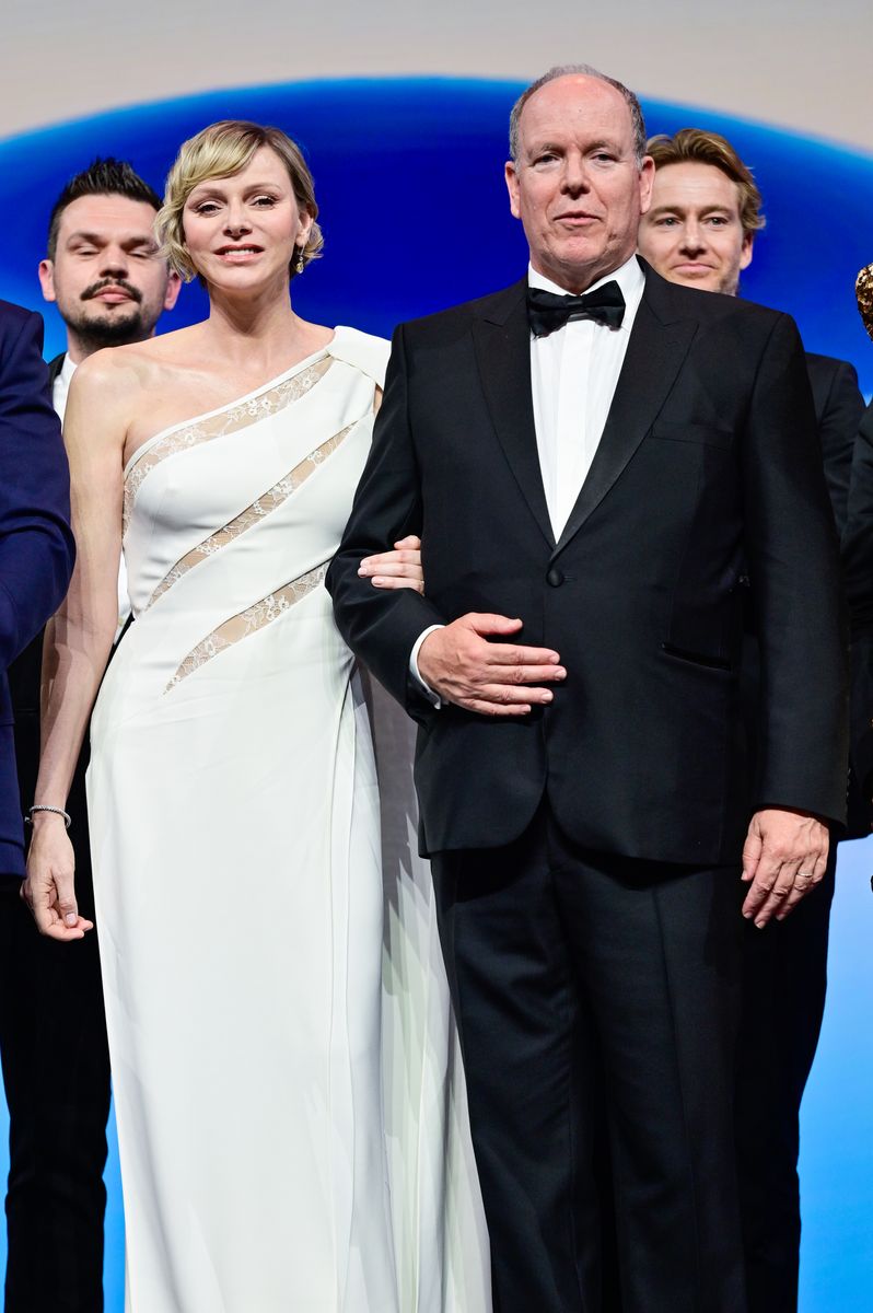 The Princess of Monaco stunned in a white Elie Saab design featuring lace inserts and a dramatic cape detail at the 2024 Monte-Carlo Television Festival.