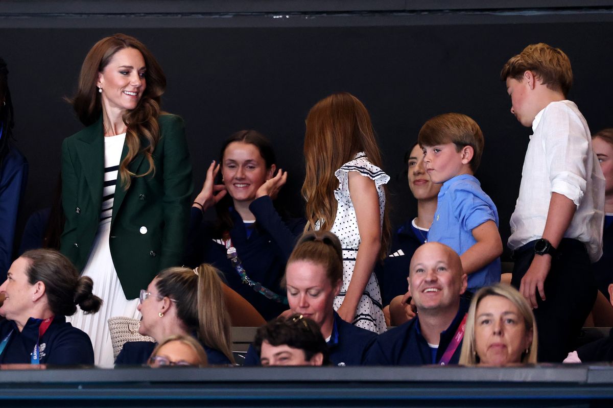 Princess Charlotte turns to speak with Kate Middleton during the match between Jamaica and Australia.