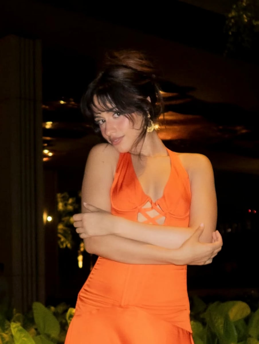Camila’s orange halter number featured a corset bodice with a deep cutout at the bust, held together by criss-cross lace-up accents.