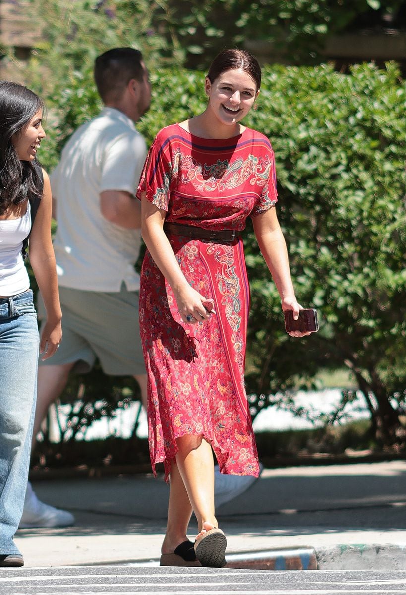 Suri Cruise was spotted stepping out for a juice wearing a red asymmetrical hem dress with a paisley print and short sleeves, cinched at the waist with a brown belt. She paired the look with black platform sandals and smiled at the cameras during her outing.