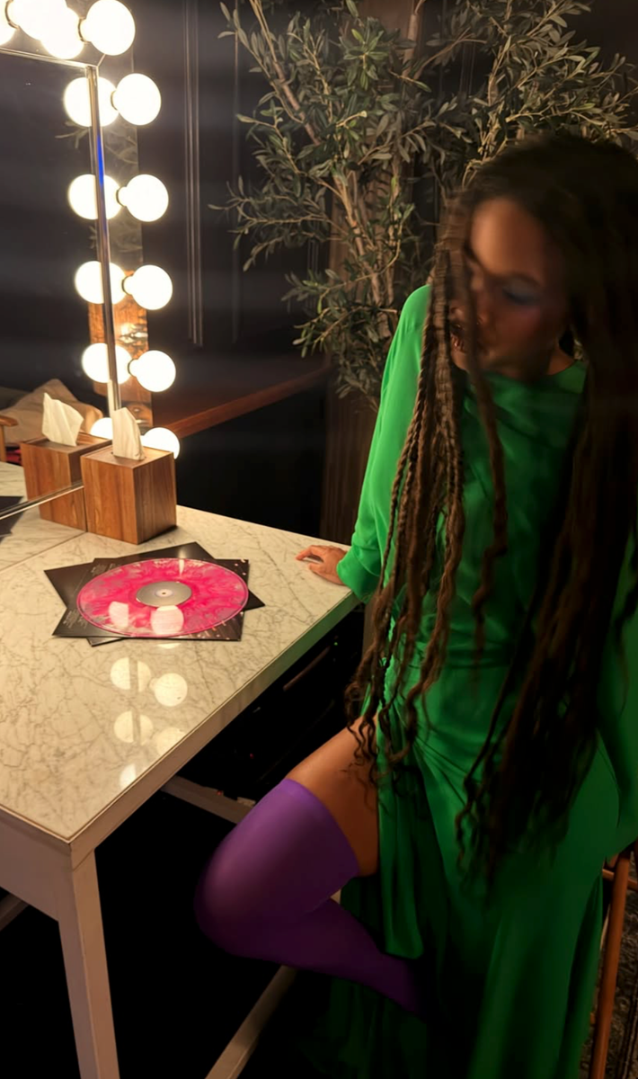 Willow Smith turned heads in a flowing emerald green dress paired with striking purple thigh-highs while teasing a major music announcement.