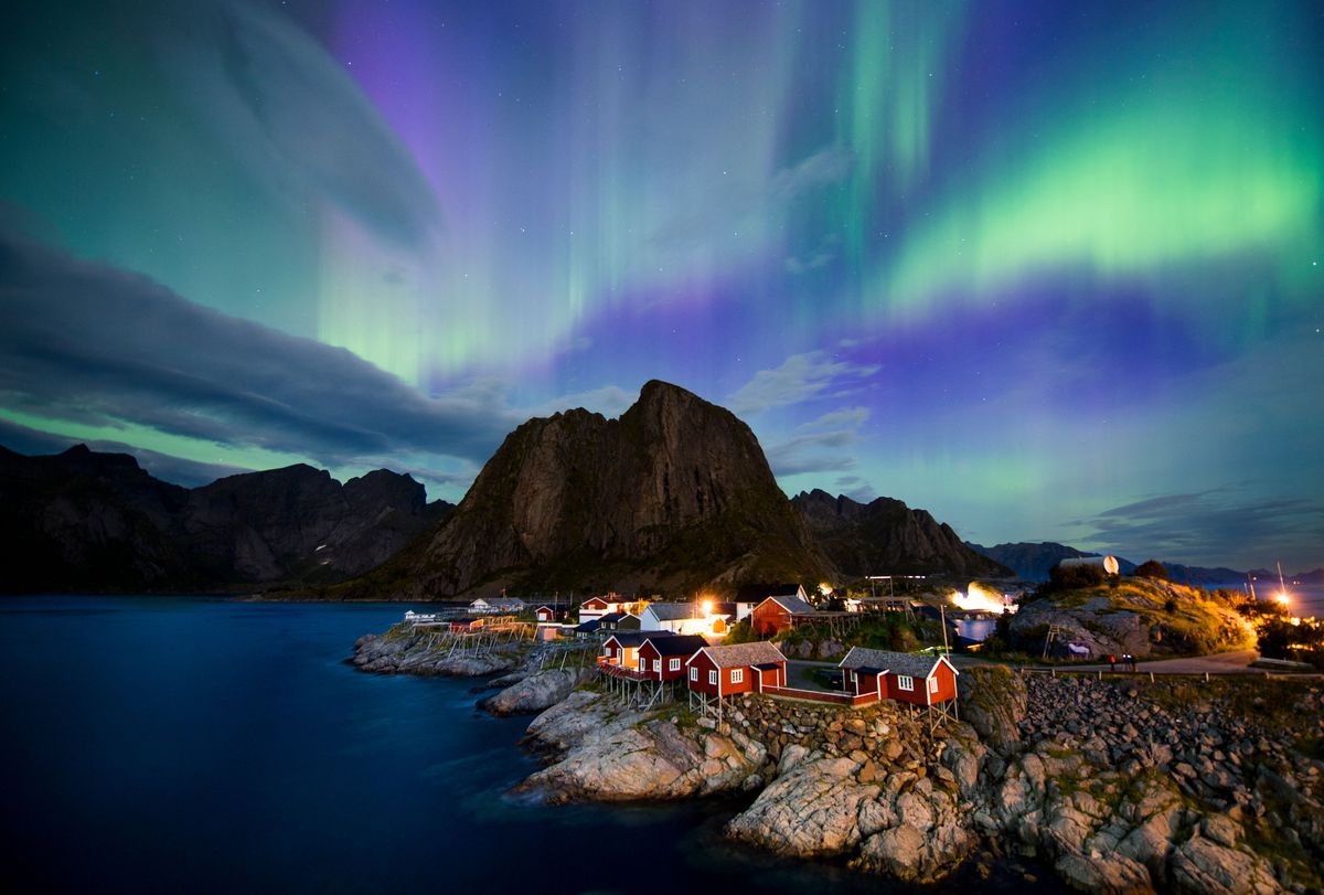 Northern lights (aurora borealis) illuminate the sky over Reinfjorden in Reine, on the Lofoten Islands, Arctic Circle, on September 8, 2017.