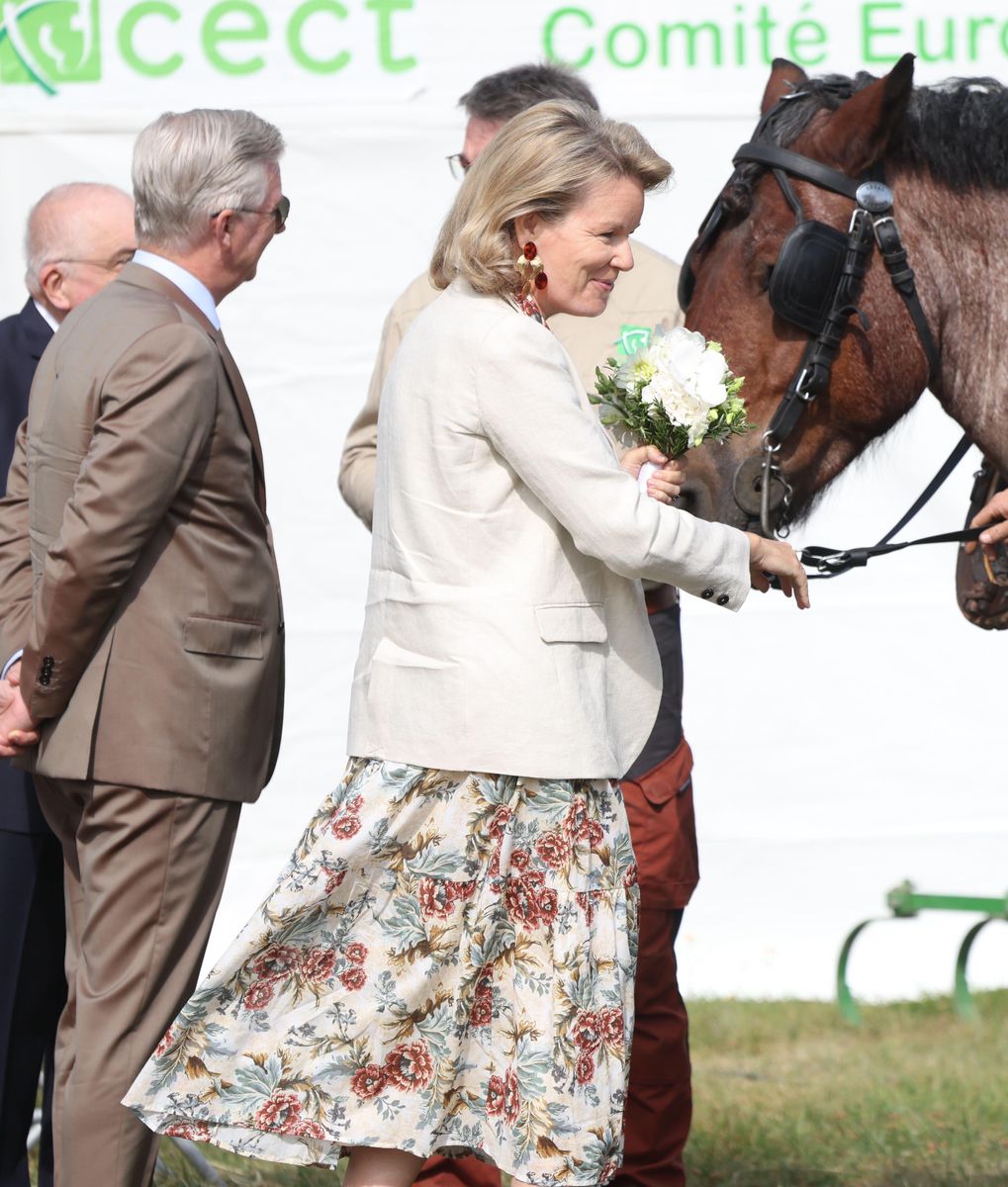 Queen Mathilde embraced timeless summer style in a romantic floral midi dress layered beneath a cream linen blazer.