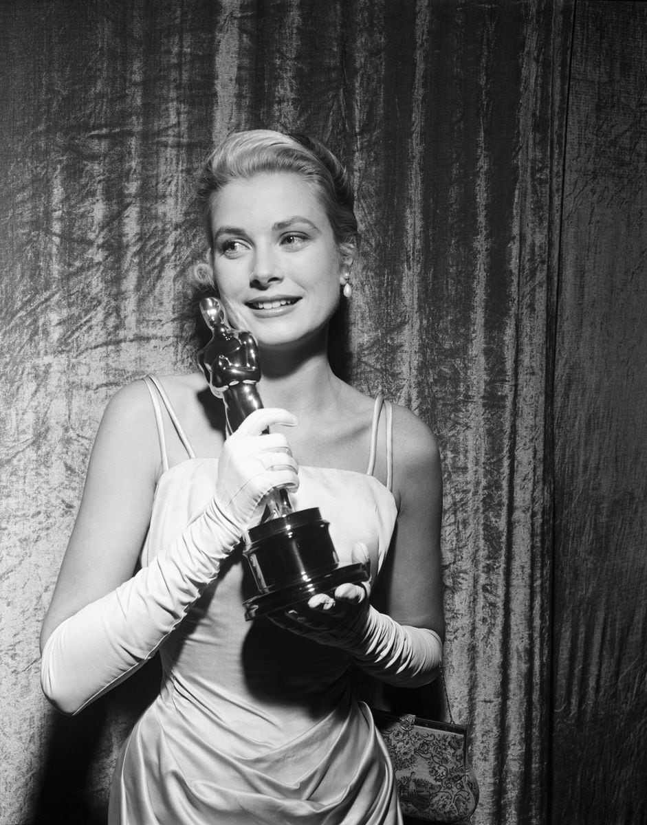 A smiling Grace Kelly clutches her Oscar after winning the coveted Academy Award