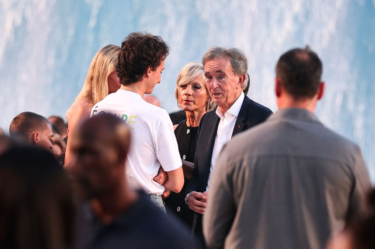 LVMH chairman and CEO Bernard Arnault (C), next to his wife, Canadian pianist Helene Mercier-Arnault, looks on as he arrives for the Louis Vuitton Menswear Spring/Summer 2027 collection