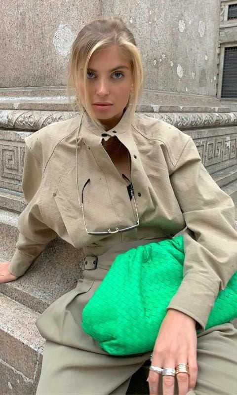 Chameleon Xenia Adonts with an outfit starring her Pouch handbag by Bottega Veneta