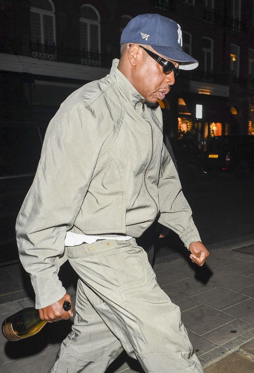 The rapper was spotted carrying a bottle of champagne as he headed into the Mayfair celebration.