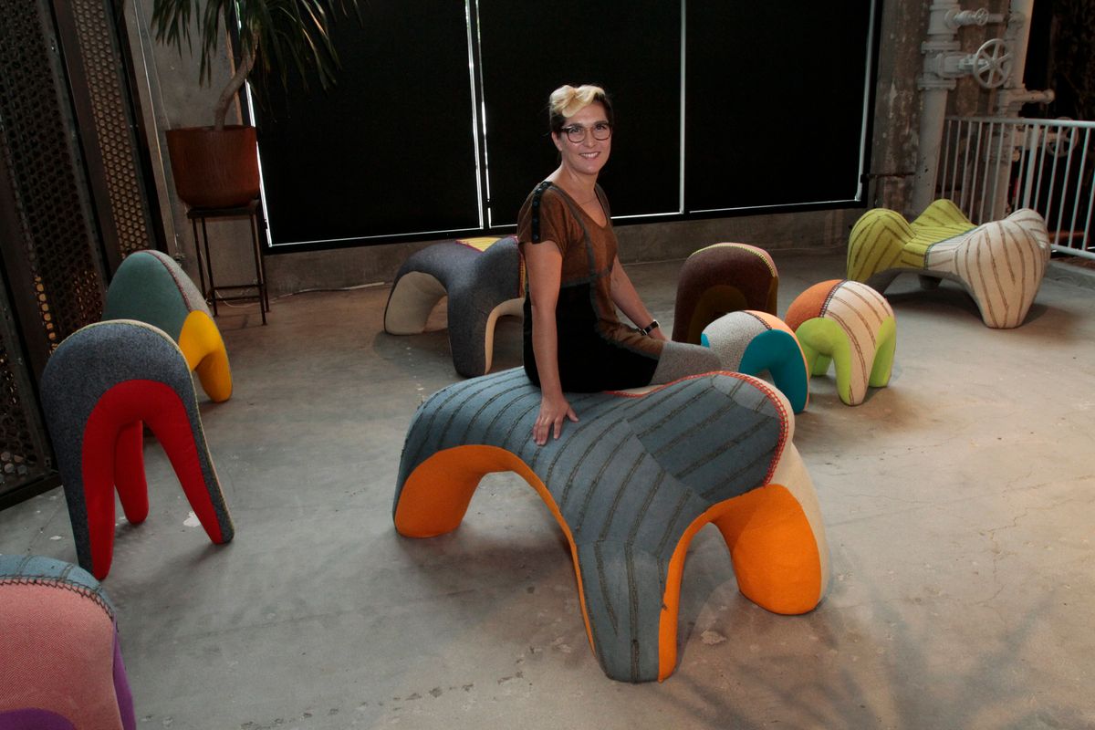 Tanya Aguiniga sits on one of her chairs called sloth as the furniture of the furniture artist is on display at JF Chen Gallery