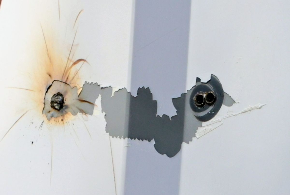 Bullet holes are seen as workers repair the exterior of the couple's Beverly Hills home