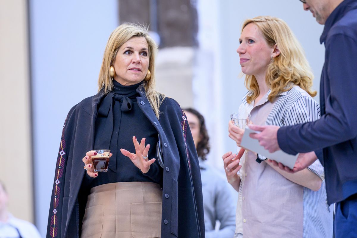 Máxima’s outfit struck a balance between polished professionalism and approachable sophistication. She wore a black pussy-bow blouse, softly tied at the neck, paired with a structured high-waisted camel skirt