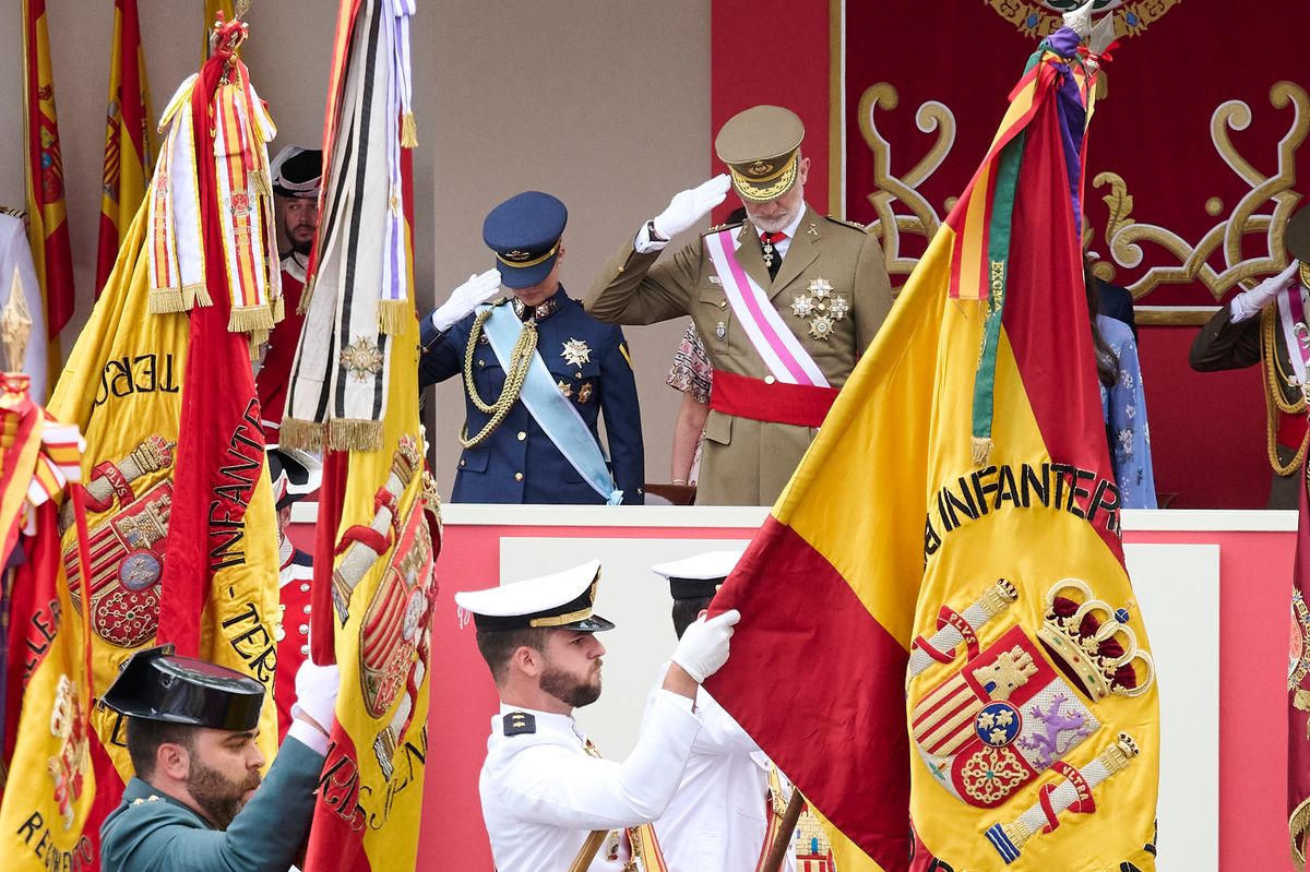The King, Queen, and Princess Leonor salute as the national flag passes during the Armed Forces Day parade.