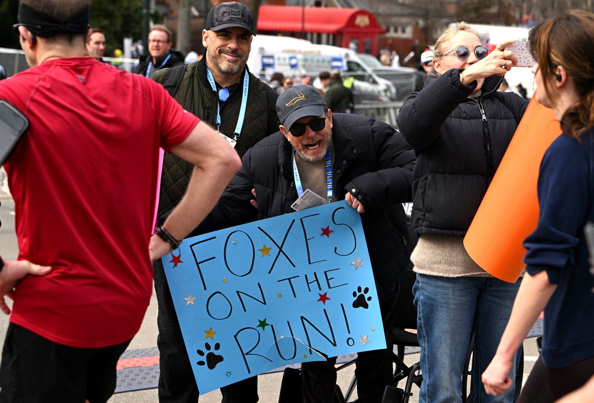 Michael J. Fox holds a sign for his daughters at the finish line during the 2026 United Airlines NYC Half Marathon in Central Park 