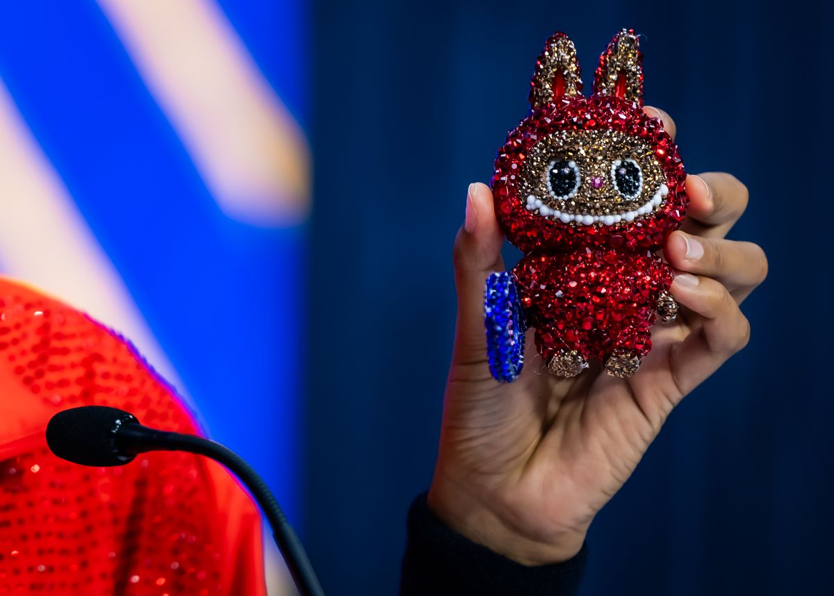 Naomi Osaka of Japan holds up her Labubu while talking to the media after defeating Greet Minnen of Belgium in the first round on Day 3 of the US Open