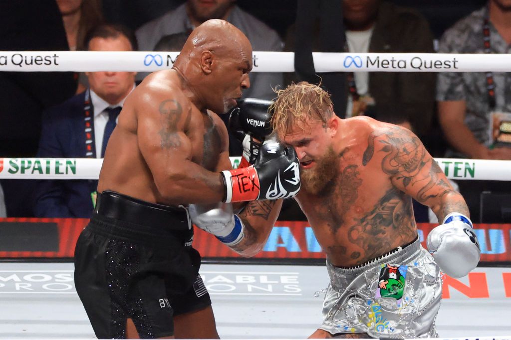 Mike Tyson punches Jake Paul during their heavyweight bout at AT&T Stadium on November 15, 2024, in Arlington, Texas. 