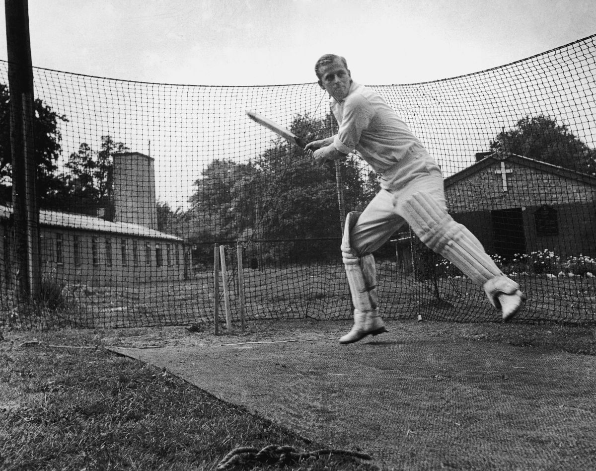 Philip Mountbatten, four months before marrying Princess Elizabeth, plays cricket with fellow Royal Navy officers in July 1947.