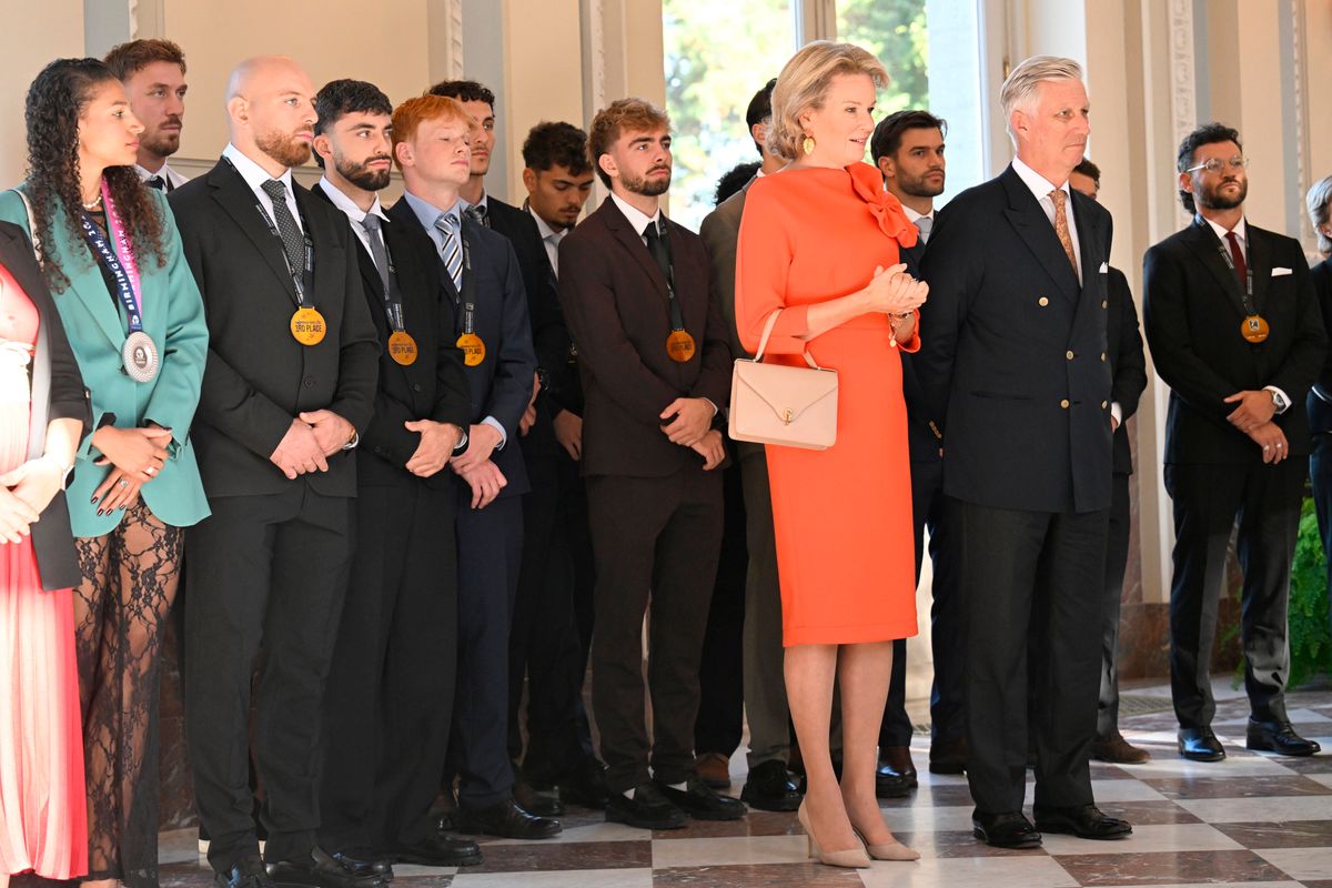 Neutral pumps and a structured handbag balanced the queen’s vibrant dress, while coordinating earrings completed her elegant look.