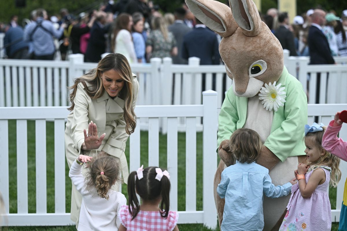 US First Lady Melania Trump high fives a young girl as she watches children play a game during the annual Easter Egg Roll on the South Lawn of the White House on April 21, 2025, in Washington, DC. According to the US National Park Service, the egg roll tradition dates back to 1878 when President Rutherford B. Hayes invited children to roll Easter eggs on the White House grounds. Children previously rolled eggs down a hill at the US Capitol in the early 1870s, but a law was passed in 1876 forbidding the Capitol property from being used due to the toll on the lawn. (Photo by Brendan SMIALOWSKI / AFP) (Photo by BRENDAN SMIALOWSKI/AFP via Getty Images)          