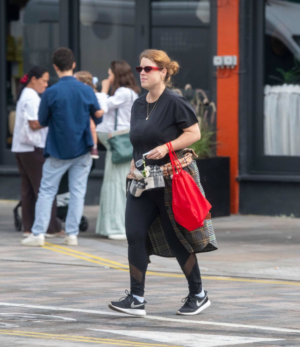 Eugenie embraced an off-duty look in a black T-shirt and leggings, completing her casual ensemble with Nike sneakers, red sunglasses and a plaid shirt tied around her waist.