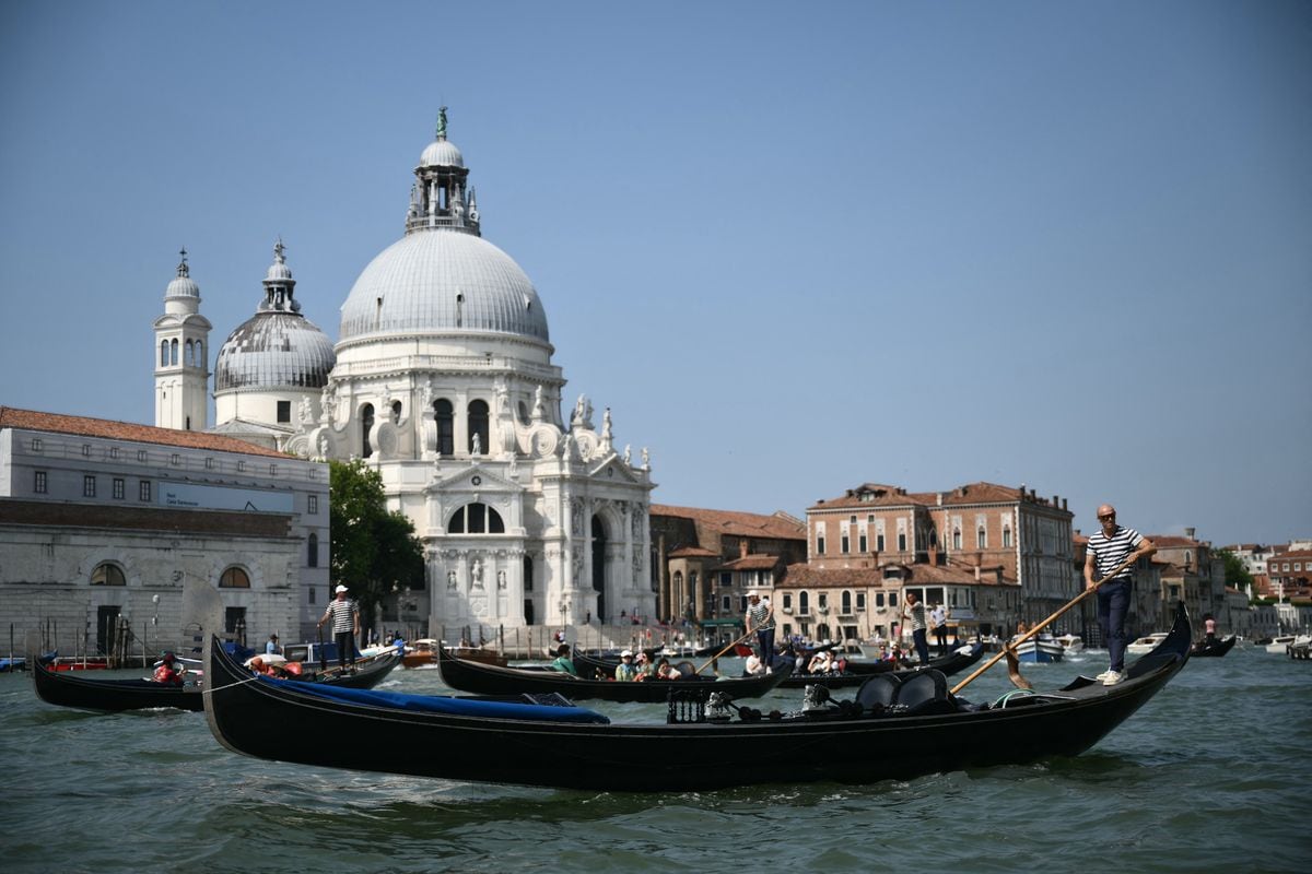 Gondoliers sail on the Grand Canal in Venice lagoon on June 25, 2026. Celebrities in superyachts sail into Venice this week for the three-day wedding party of Amazon tycoon Jeff Bezos and Lauren Sanchez