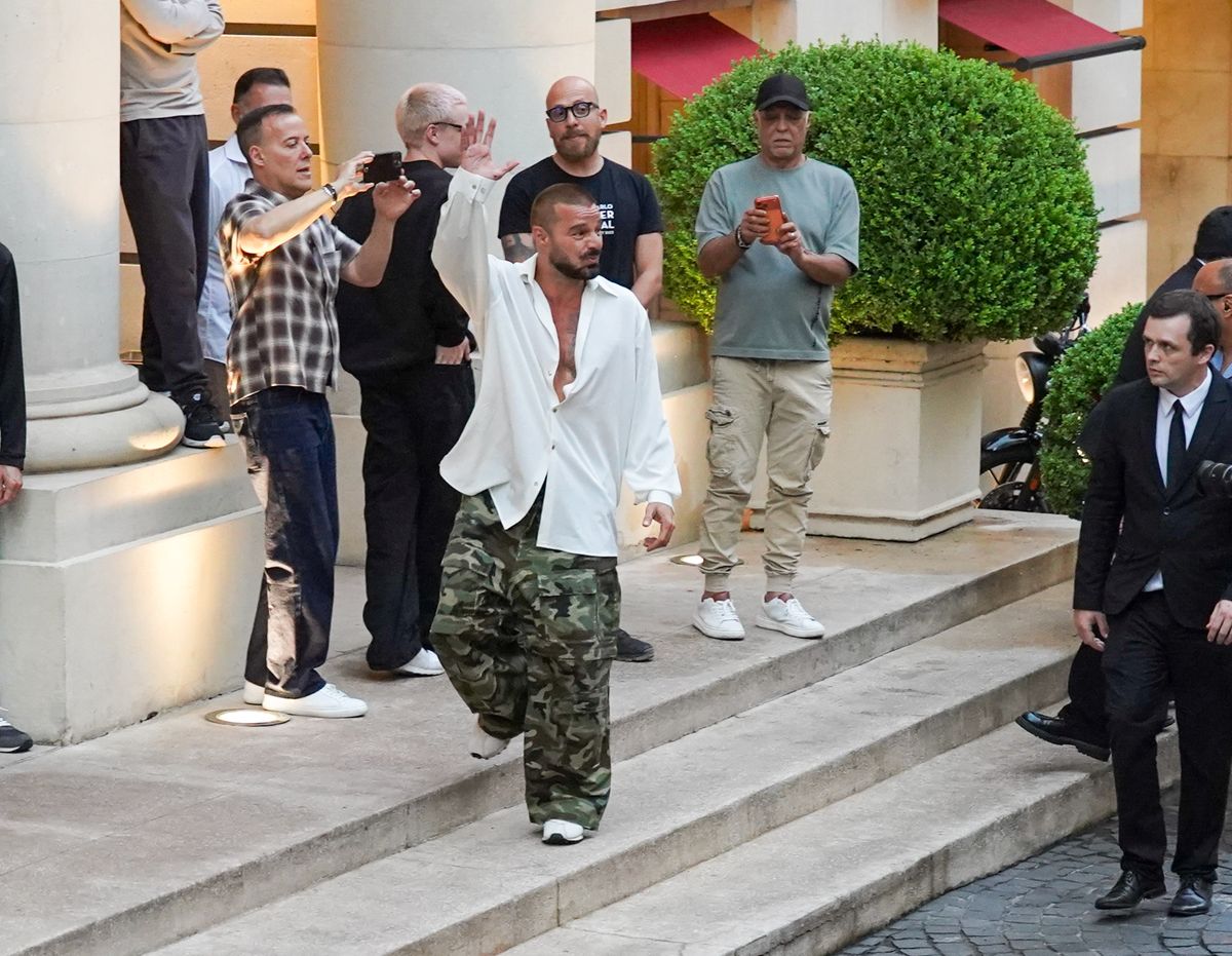 Ricky Martin comes out to wave from his window and then the hotel's entrance patio.