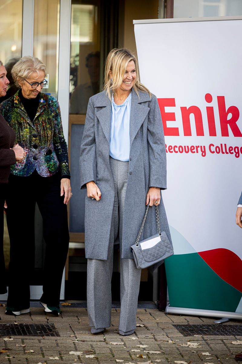Queen Maxima of The Netherlands accessorized with subtle jewelry, including dangling earrings and her engagement ring, reflecting her signature understated elegance.
