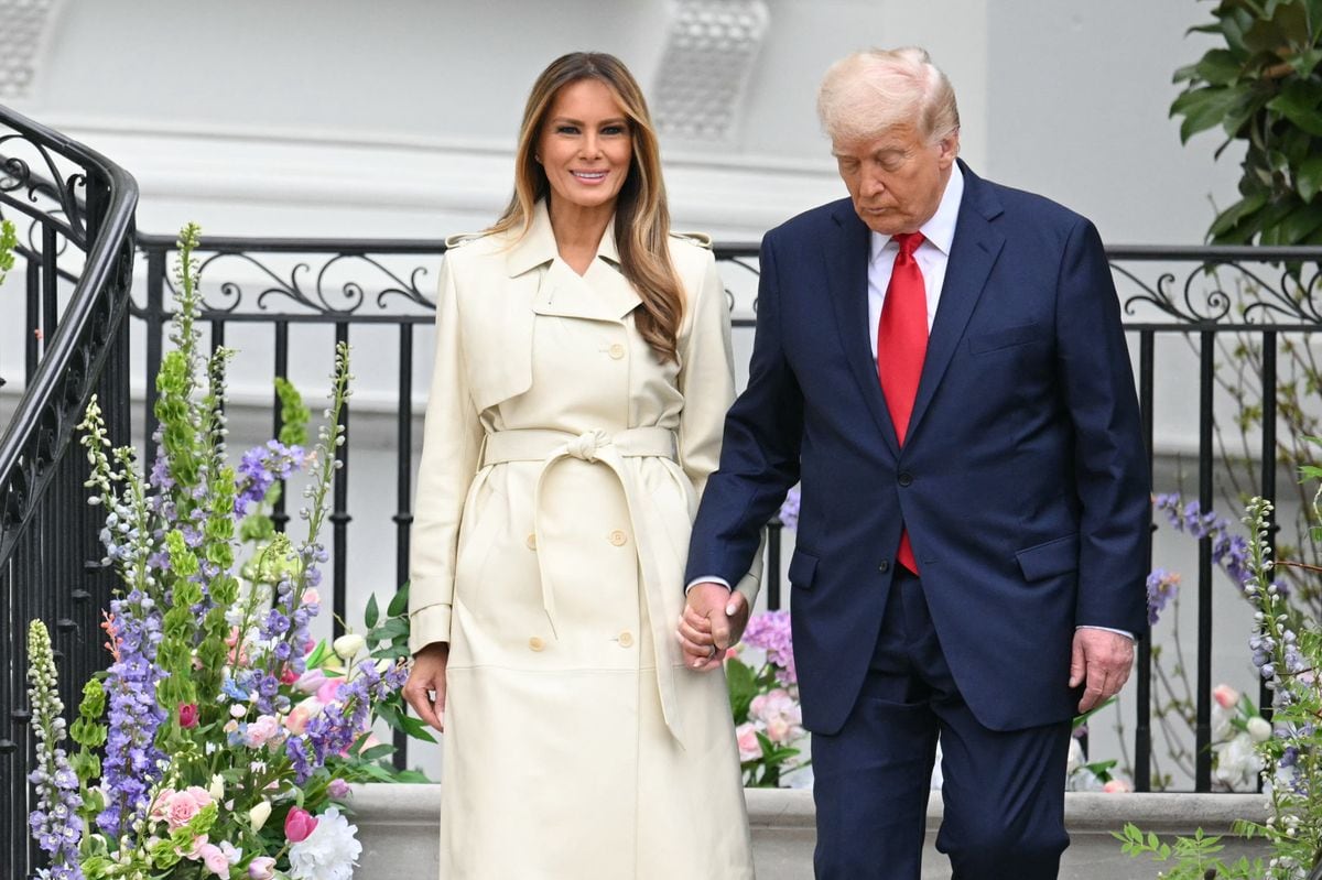 President Donald Trump and First Lady Melania Trump walk down the stairs from the Blue Room Balcony to the South Lawn as they host the annual Easter Egg Roll at the White House