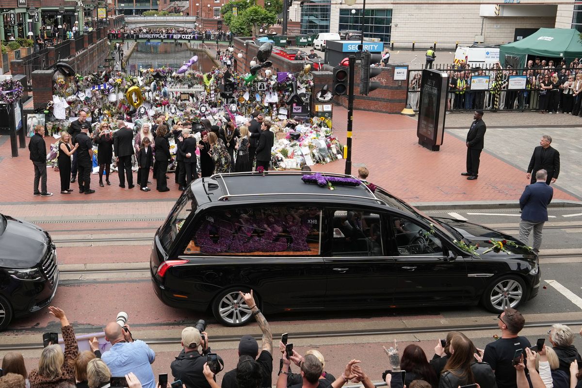Sharon Osbourne, Jack Osbourne, Kelly Osbourne, and Aimee Osbourne stop to view tributes to the late Ozzy Osbourne from fans at Black Sabbath Bench and Bridge as his funeral cortege travels through his home city of Birmingham on July 30, 2025 in Birmingham, England.