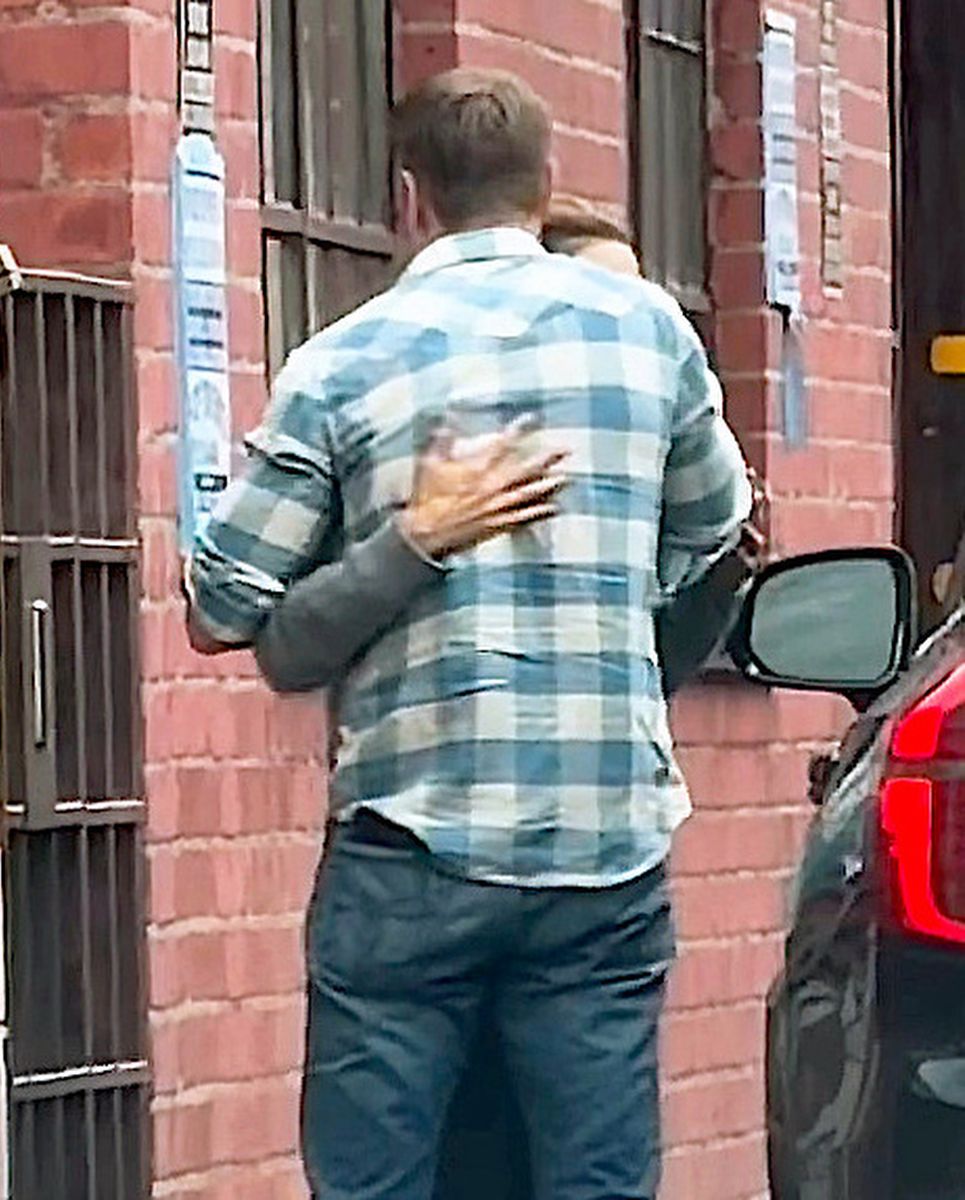 Actress Jennifer Garner and John Miller embrace in the rain during outing in Brentwood.