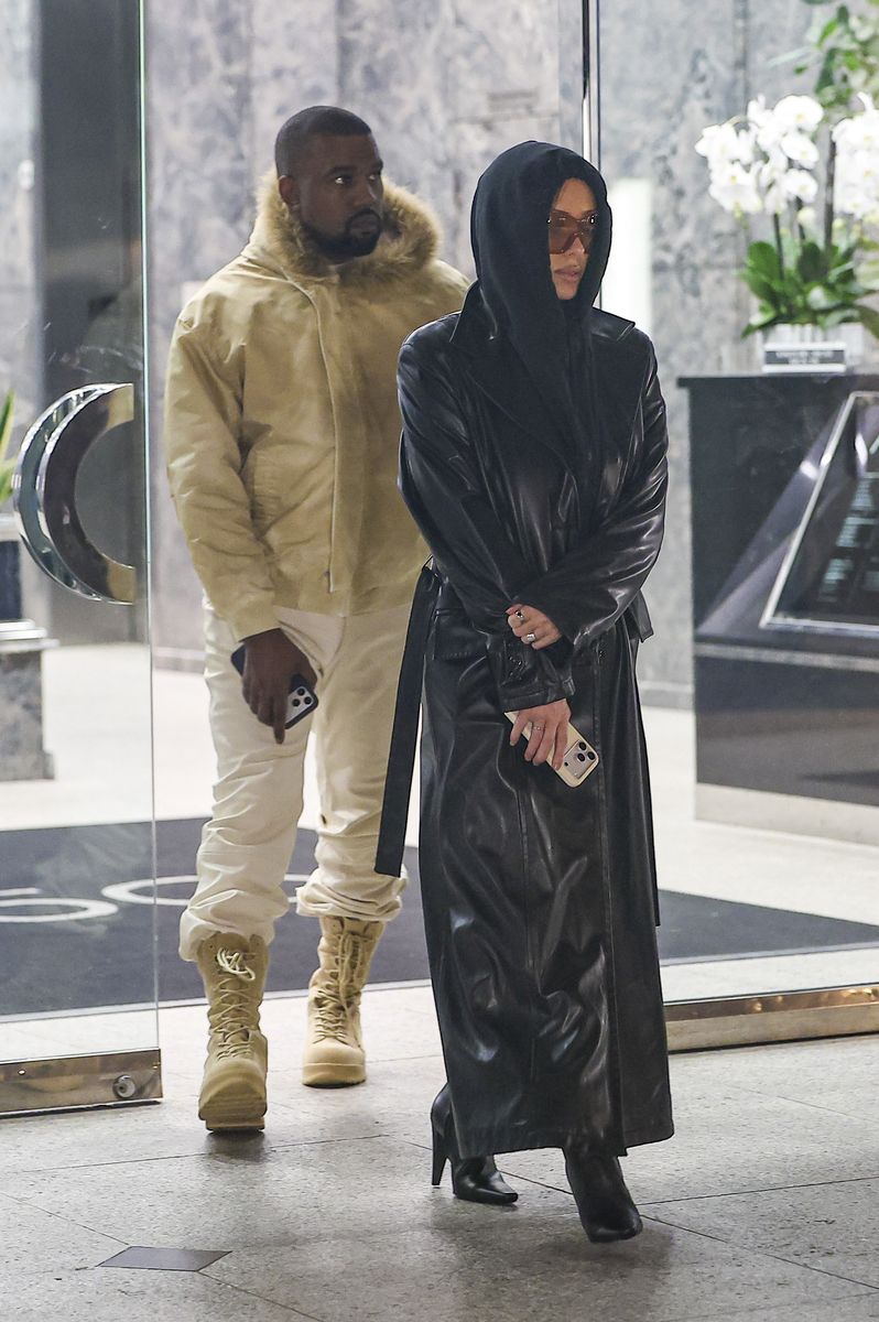 Photo 2026 Backgrid/The Grosby Group
EXCLUSIVE
Los Angeles, CA, Octobe 5, 2026. Ye and Bianca Censori leave a movie theater in Westwood after a low-key date night together, one day after their appearance at ComplexCon. Despite temperatures in Los Angeles reaching around 100°F, both step out in heavy outerwear. Censori wears a floor-length glossy black leather trench coat with structured shoulders, wide lapels, long sleeves, and a belted construction over a black hooded top and fitted black leggings. She completes the look with dark brown knee-high stiletto boots and oversized amber-tinted rectangular sunglasses. Ye wears a beige hooded bomber jacket with a fur-trimmed hood, zip-front construction, ribbed hem and cuffs, and a relaxed fit, paired with off-white trousers and tan lace-up combat boots with thick soles.***Ye y Bianca Censori salen de un cine en Westwood después de una cita nocturna discreta, un día después de su aparición en ComplexCon. A pesar de que las temperaturas en Los Ángeles rondaron los 100 °F, ambos llevan prendas de abrigo pesadas. Censori viste un trench negro de cuero brillante hasta el suelo, con hombros estructurados, solapas anchas, mangas largas y cinturón, sobre un top negro con capucha y leggings negros ajustados. Completa el look con botas marrón oscuro hasta la rodilla de tacón aguja y gafas de sol rectangulares oversized con lentes ámbar. Ye lleva una bomber beige con capucha ribeteada en pelo, cierre frontal, puños y bajo acanalados y corte relajado, combinada con pantalones off-white y botas de combate marrón claro con cordones y suela gruesa.
Byline: BACKGRID /SPOT, BUFR, NGRE, RMCL / GROSBY GROUP